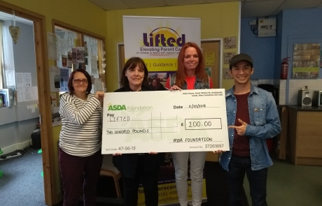 Lifted's Sue, Christine, Emma, and Jordan holding the £200 cheque from Asda Wythenshawe