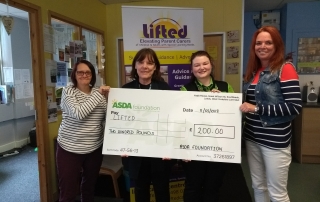 Lifted's Sue, Christine, and Emma receiving the £200 cheque from Asda Wythenshawe's Community Champion, Rebecca