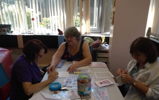 Sue, Karen, and Christine making handmade cards during Crafts Day at Lifted Carers' Centre