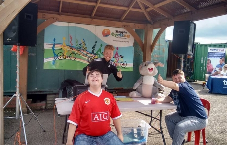 The DJ with two young adults with SEND at the Festival in the Park 2017 in Wythenshawe Park Athletics Track