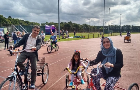 A family of 3 cycling at the Festival in the Park 2017 in Wythenshawe Park Athletics Track