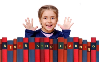 a smiling girl with a load of books spelling "NEVER STOP LEARNING" | image source: Geralt from Pixabay.com