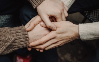 Hands of two people held together. There are small logos of the Lifted and Carers Week logos on the left and right top corners, respectively.